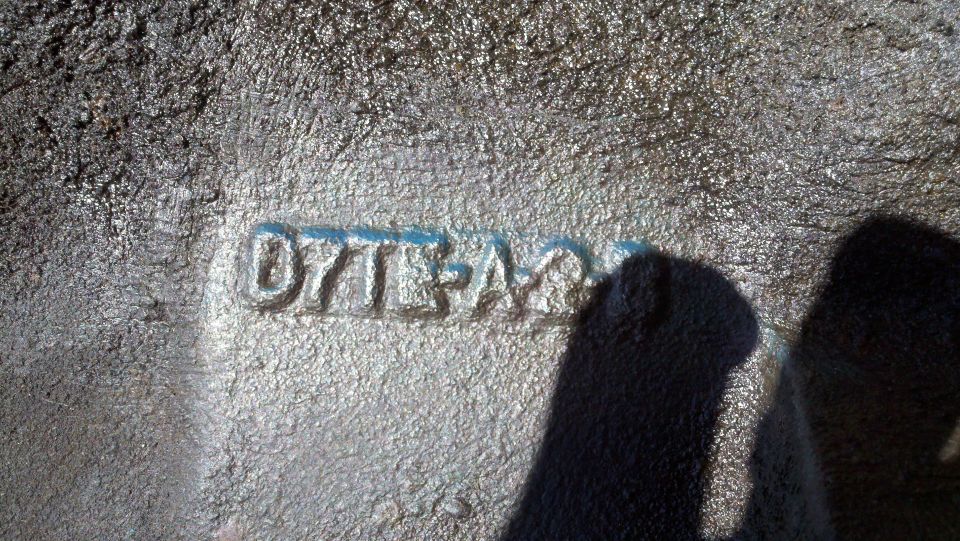 Close-up of a metal part with stamped numbers 'D7TA-6015-AA'