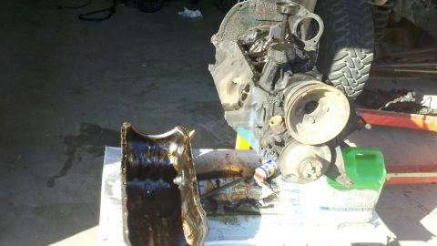 1978 Ford Bronco - Engine block and oil pan removed for motor rebuild, with tools and fluids present.