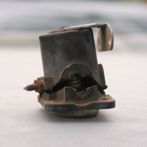 1976 Ford Ranchero - A damaged battery component is shown, with visible cracks in the plastic casing and a rusty bolt.