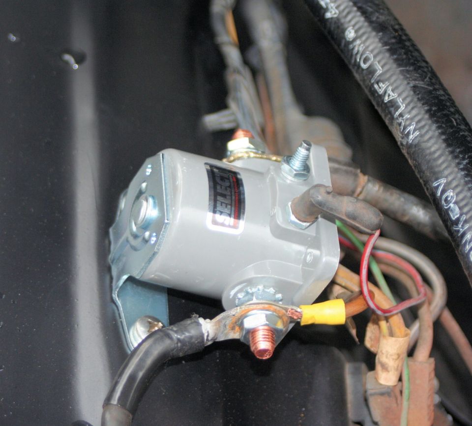 Starter solenoid with wiring and a black hose labeled NYLAFLOW