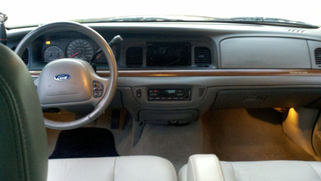 Interior view of a Ford Crown Victoria dashboard with steering wheel and seats.