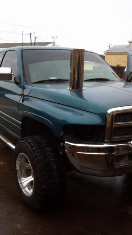 1997 Dodge 2500 - This teal 1997 Dodge 2500 pickup features a prominent chrome exhaust stack rising from the hood.