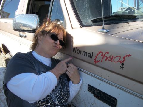 1996 Ford Bronco - A woman points to a "Normal Chaos" decal on the side of a Ford Bronco.