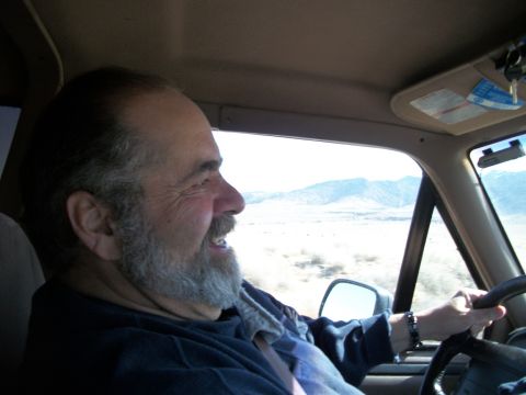 1996 Ford Bronco - Man driving a truck through a desert landscape.