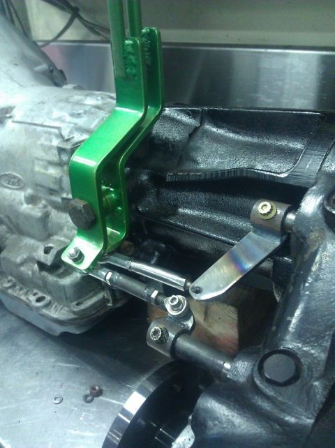 1979 Ford Bronco - Close-up of a green shift linkage mechanism installed on a vehicle transmission.