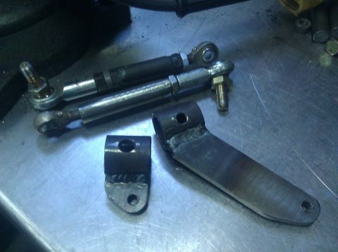 1979 Ford Bronco - Custom fabricated steering linkage components are laid out on a metal surface.