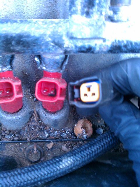 1999 Dodge 1500 - A hand disconnects an electrical connector from a fuel injector assembly.