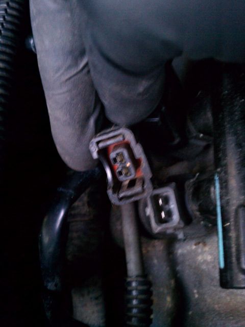 1999 Dodge 1500 - A gloved hand is shown disconnecting an electrical connector with two pins.