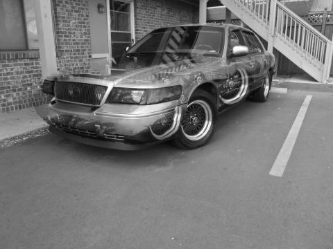 2000 Mercury Grand Marquis - This sedan has a unique paint job and visible internal wheel components.