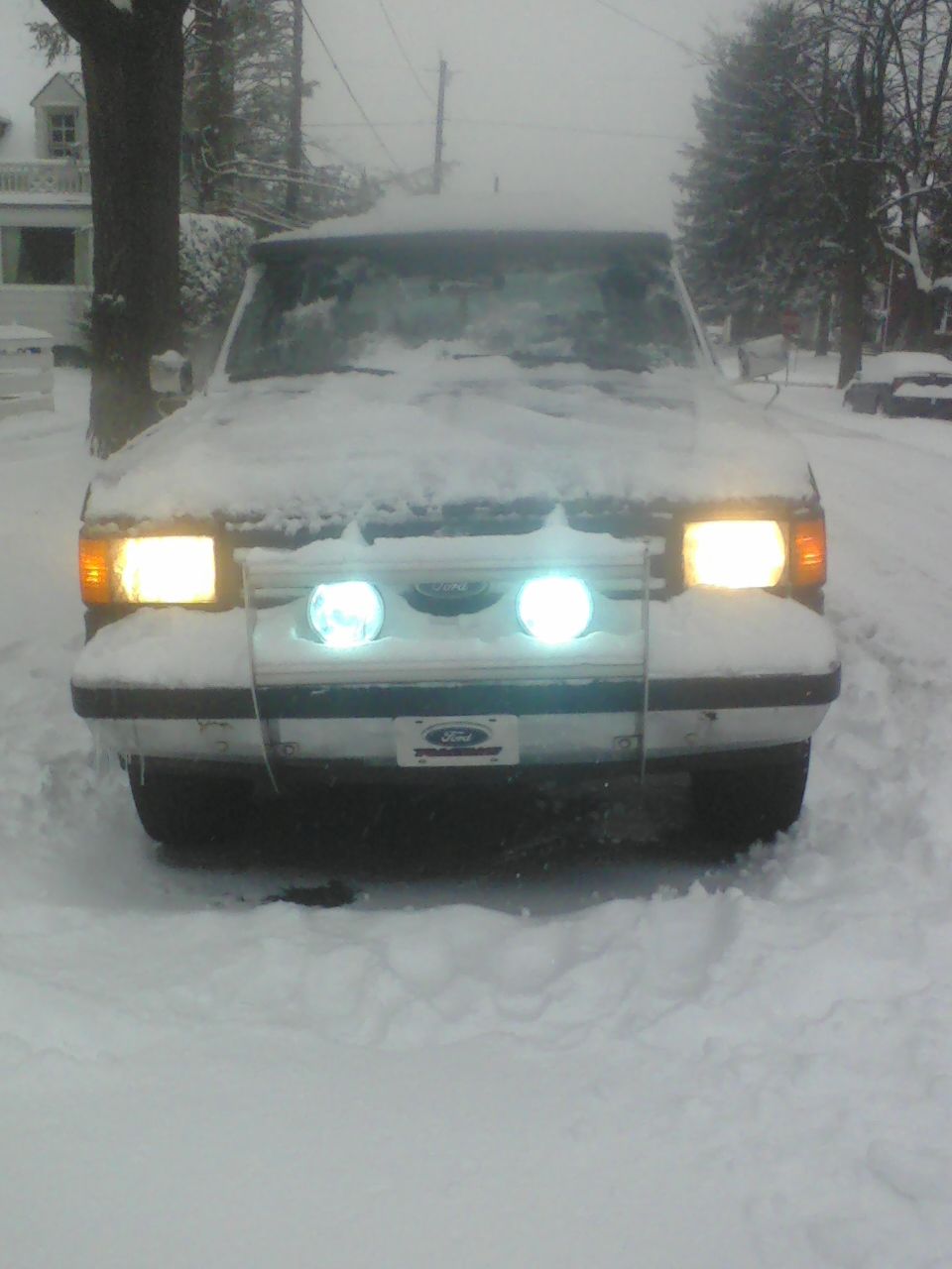 1988 Ford Bronco front view in snow, headlights on
