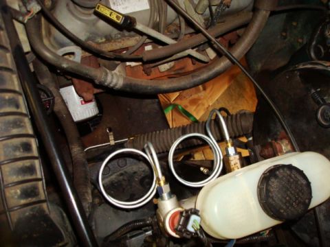 1995 Ford Bronco - Close-up view of the engine bay of a 1995 Ford Bronco, showing the brake fluid reservoir and brake lines.