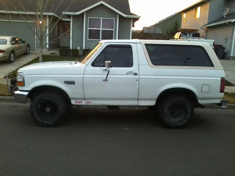 1992 Ford Bronco - A white 1992 Ford Bronco SUV is parked on a residential street.
