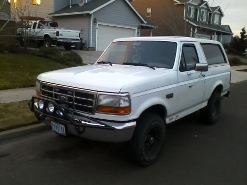 1992 Ford Bronco - This white 1992 Ford Bronco is seen from a 3q-front angle, an aftermarket bumper and auxiliary lights.