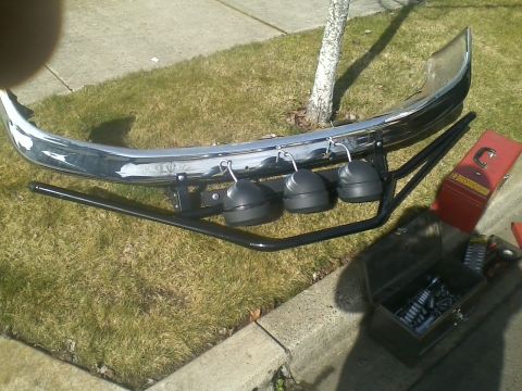 1992 Ford Bronco - A chrome bumper assembly with auxiliary lights and a toolbox are laid out on the grass.