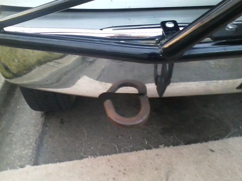 1992 Ford Bronco - Close-up of a vehicle's front bumper and tow hook, with a roll cage visible.