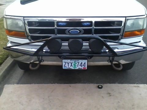 1992 Ford Bronco - Front view of a 1992 Ford Bronco a chrome grille, bull bar, and auxiliary lights.
