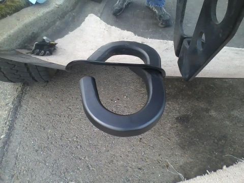 1992 Ford Bronco - Close-up of a black tow hook and a tire on asphalt.