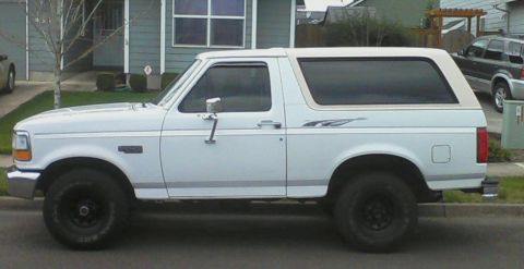 1992 Ford Bronco - A white 1992 Ford Bronco is seen from the side in a suburban setting.