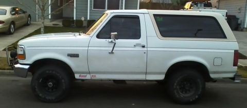 1992 Ford Bronco - This white Ford Bronco is shown from the side, parked on a residential street.