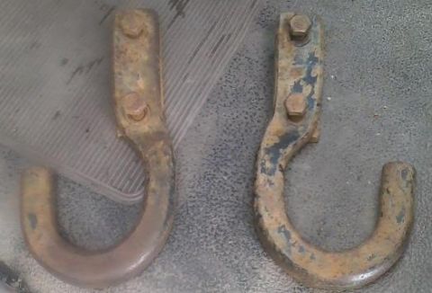 1992 Ford Bronco - Two rusty tow hooks are shown, one with remnants of blue paint.