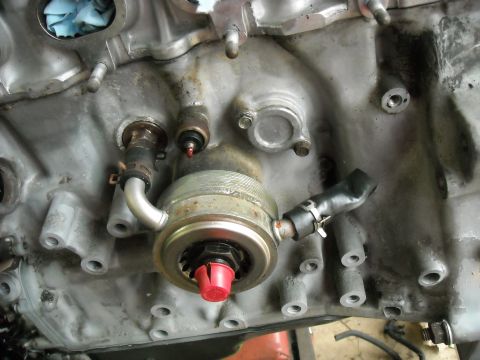 1979 Ford F-150 - Close-up view of an engine block the oil filter housing with a red protective cap.