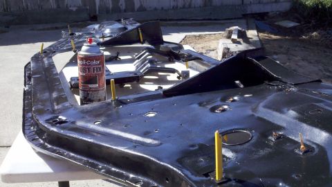 1978 Ford Bronco - A car door frame is being treated with rust fix spray.