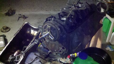 1978 Ford Bronco - Engine block and oil pan removed for motor rebuild, surrounded by tools and parts.