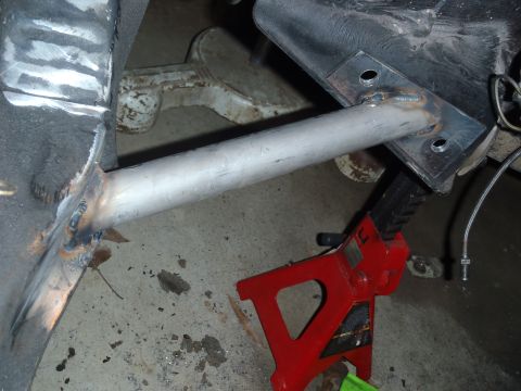 1978 Nissan 300ZX - A close-up view of a vehicle's frame with a newly welded metal bar, resting on a jack stand.