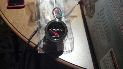 1979 Ford Bronco - A new transmission temperature gauge is shown in its packaging, ready for installation.