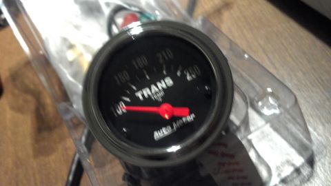 1979 Ford Bronco - Close-up of an Auto Meter transmission temperature gauge, showing the needle at 140 degrees.
