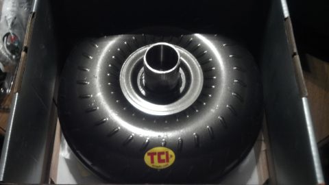1979 Ford Bronco - A TCI torque converter is shown inside its packaging, highlighting its metallic components and stud pattern.