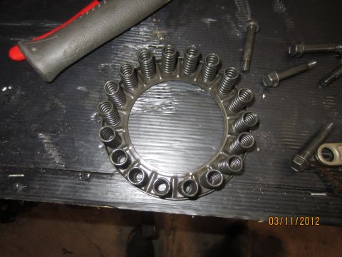 1979 Ford Bronco - Clutch pressure plate with springs and bolts on a workbench, dated 03/11/2012.