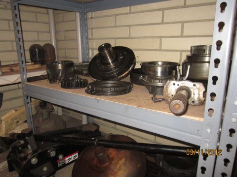 1979 Ford Bronco - Assorted transmission parts are organized on a metal shelf, with a date stamp visible in the lower right corner.