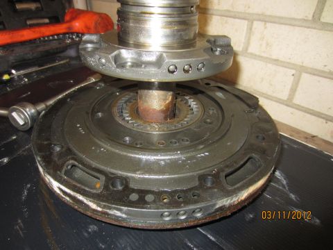 1979 Ford Bronco - A close-up view of a disassembled transmission part, showing internal gears and a rusty shaft.