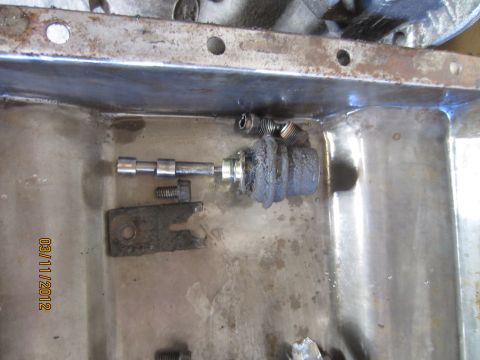 1979 Ford Bronco - Close-up of a transmission part removed and placed in a pan.