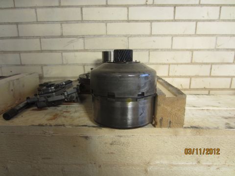 1979 Ford Bronco - Transmission parts, including a torque converter, are displayed on a workbench.