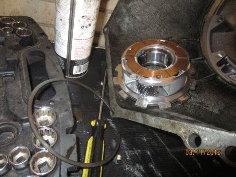 1979 Ford Bronco - A disassembled transmission planetary gear set and clutch plates are laid out on a workbench with tools.