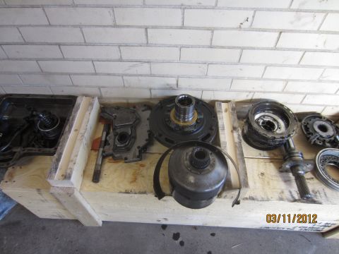 1979 Ford Bronco - Various transmission parts are disassembled and arranged on a wooden crate, with a date stamp of 03/11/2012 visible.
