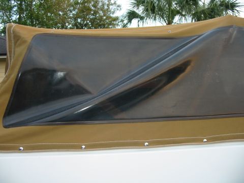 1992 Ford Bronco - Close-up of a tan soft top with a wrinkled plastic window, likely for a convertible or Jeep-style vehicle.