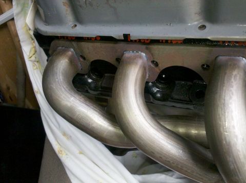1996 Ford Bronco - Close-up view of exhaust manifold pipes and engine block, showing gasket material.