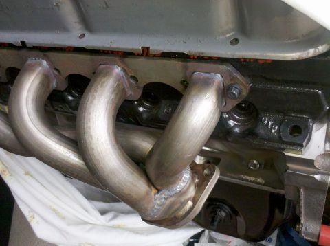 1996 Ford Bronco - Exhaust manifold welded and bolted to the engine block, part of a motor build.