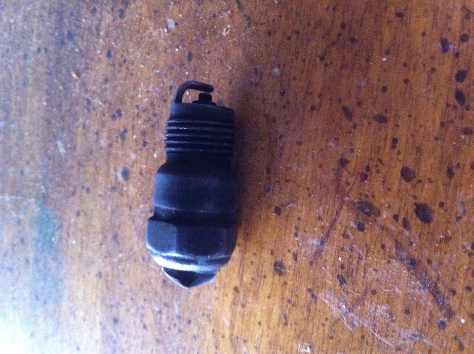 Used spark plug on a wooden surface