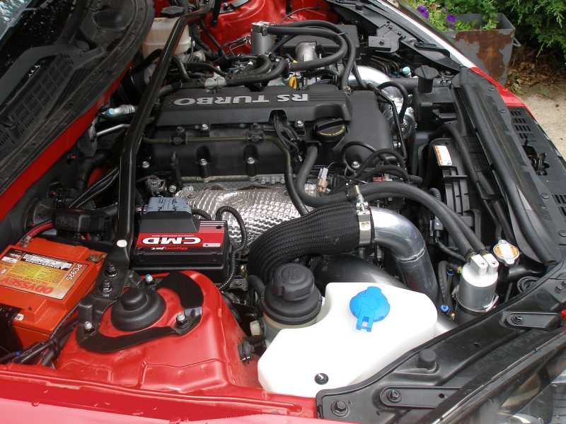 Engine bay showing turbocharger, battery, and fluid reservoirs