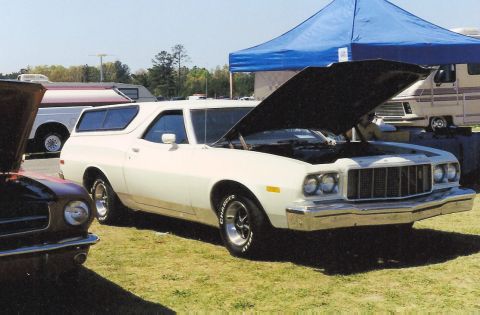 1976 Ford Ranchero - A white 1976 Ford Ranchero is parked on a grassy field with its hood up, alongside other vehicles.