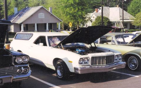 1976 Ford Ranchero - White 1976 Ford Ranchero on display with its hood open, parked alongside other cars.