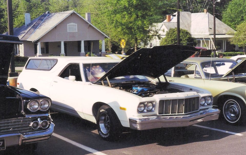 1976 Ford Ranchero with hood open, parked next to other vehicles