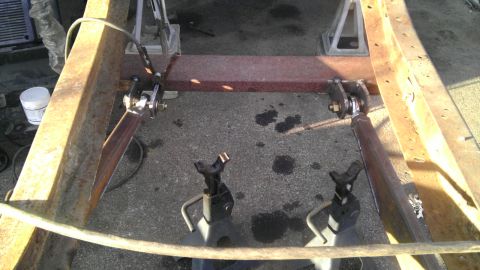 1987 Ford Ranger - Close-up of truck frame and suspension parts, resting on jack stands.