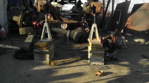 1987 Ford Ranger - The underside of a vehicle, likely undergoing maintenance or repair, is supported by jack stands and wooden blocks.