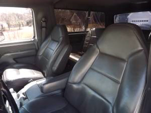1993 Ford Bronco - The interior of a vehicle shows leather seats and a dashboard with a watermark.