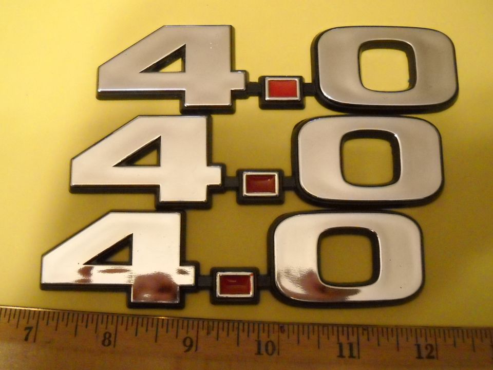 Three chrome 4.0L V6 badges with red accents